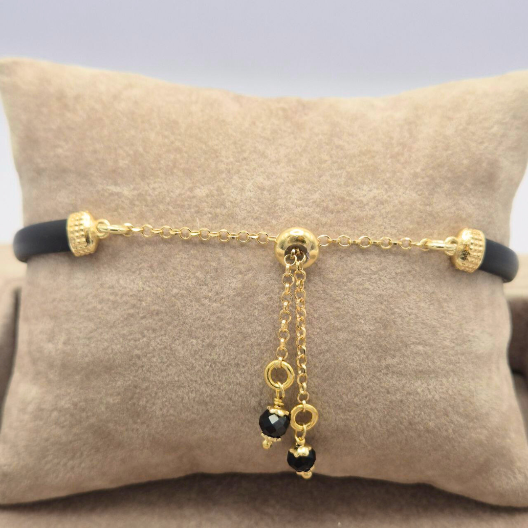 Bracciale in caucciù nero con inserti in Argento 925 dorato e bottoncino con pietra naturale a scelta. Chiusura con saliscendi