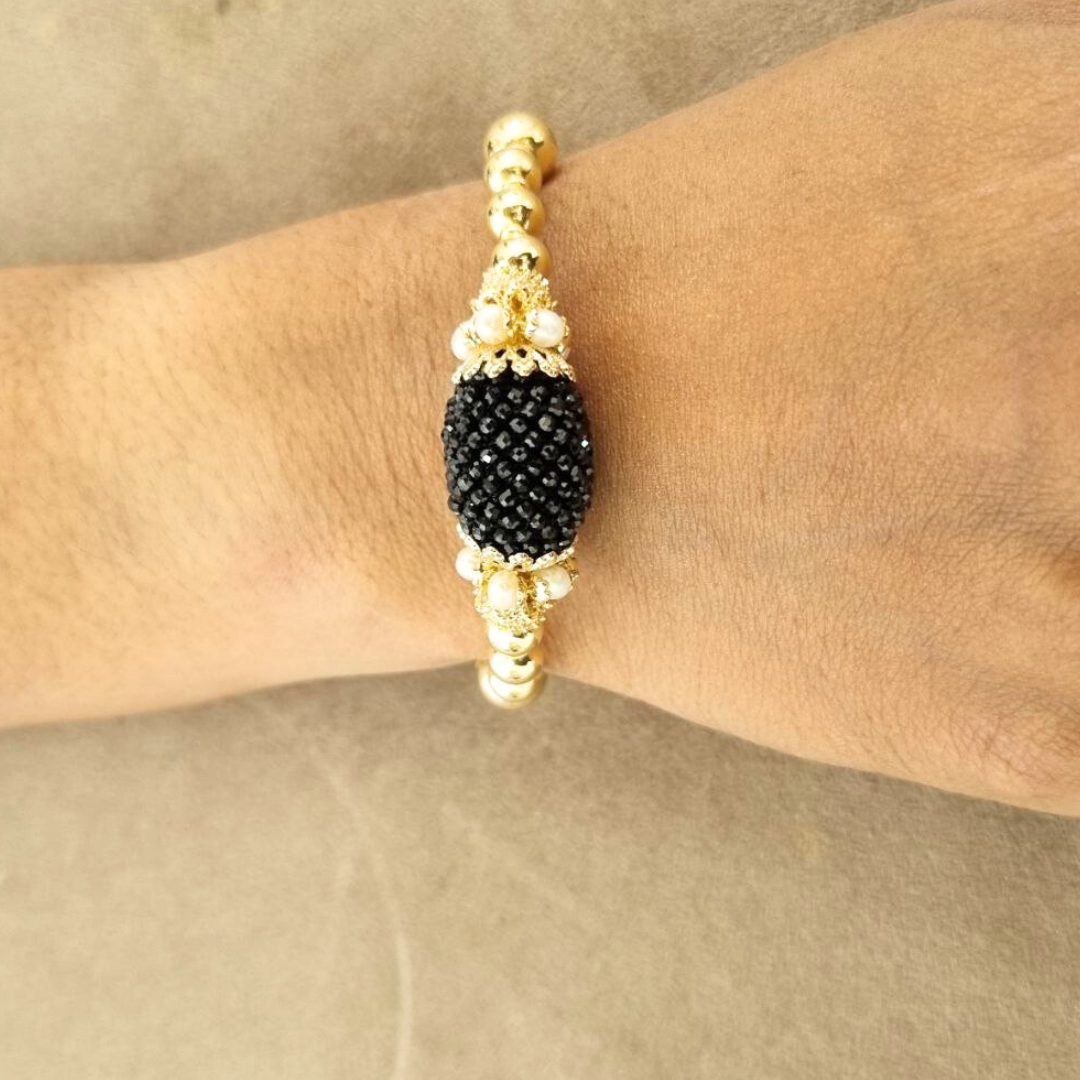 Bracciale semirigido linea Barocca con sfere in Argento 925 dorato e oliva centrale in Spinelli neri lavorazione tessito con coroncine in Perle